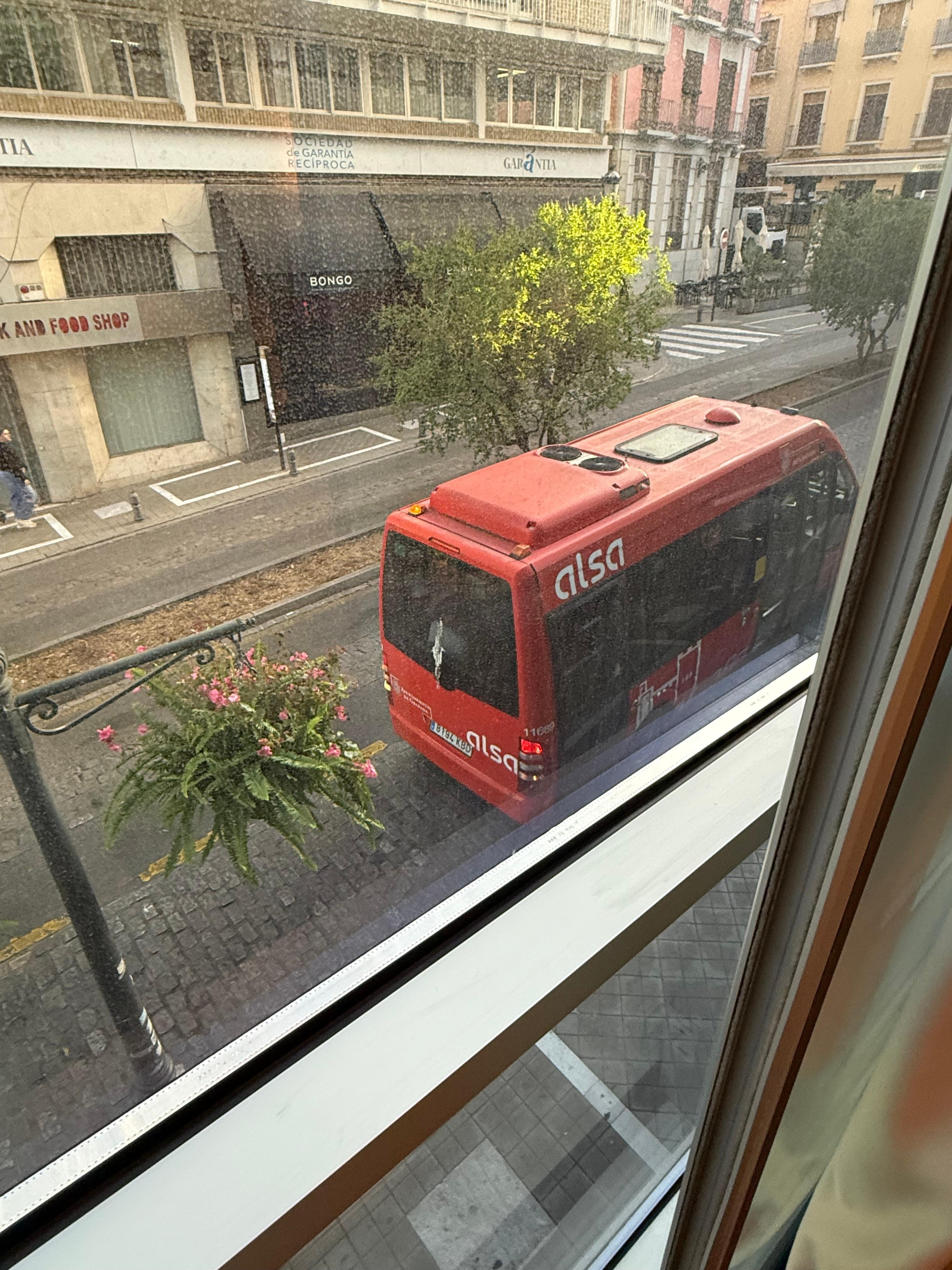 Bus right below the room with wall to ceiling windows 