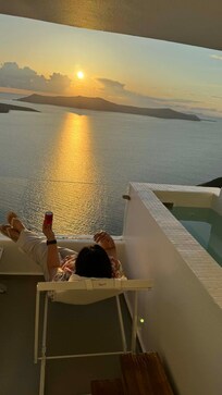 Our hotel balcony overlooking the caldera, bathed in a stunning sunset.
