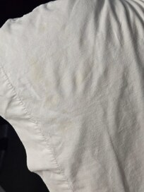 Yellow undetermined stains on upper corners of 2 pillows