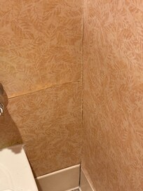 Water leaking thru wall into men’s bathroom off lobby.