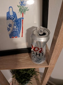 Opened beer cans (half full) in the living room.