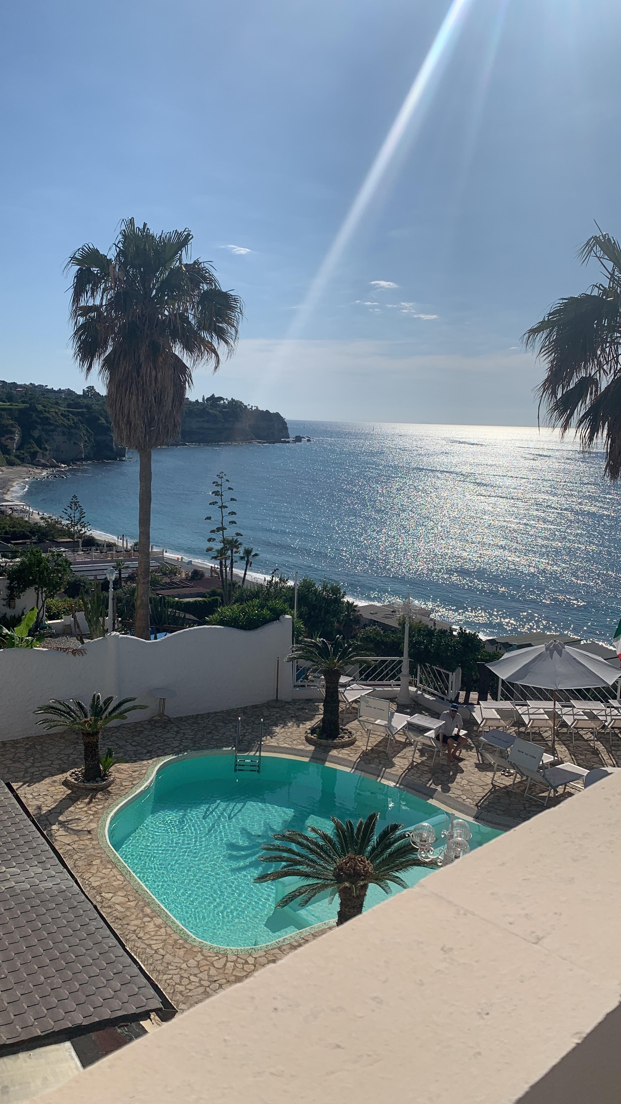 View from 2nd  patio of our bedroom with 2 chairs and small table.  View of pool and other side of ocean
