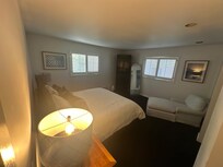 Bedroom number 2, large bed and comfy chaise lounge complete with wardrobe closet filled with blankets and towels.
