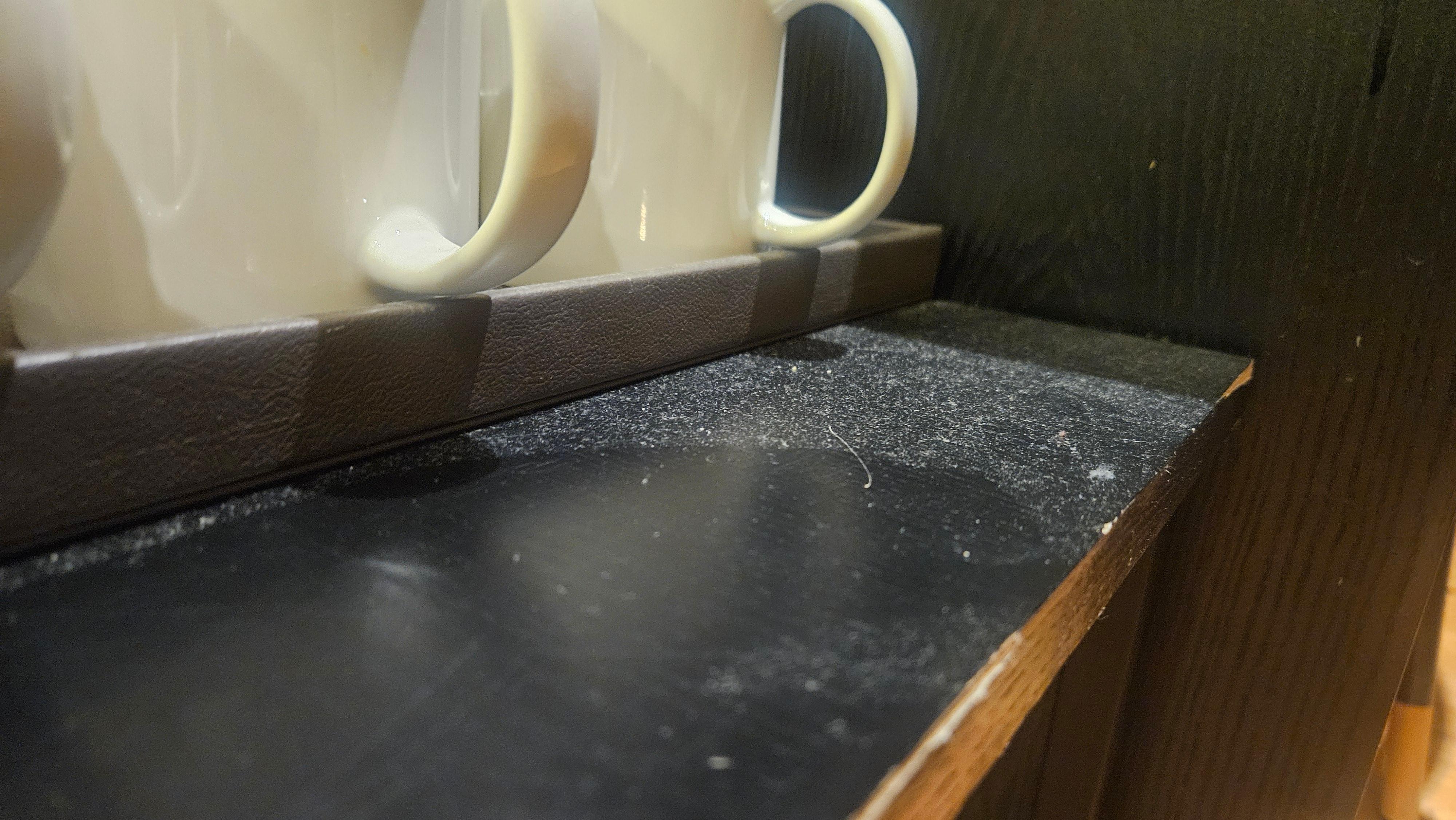 커피잔 놓인 테이블을 손으로 훔치니 먼지가 사방에 날림