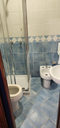 If bidet was not there, the shower enclosure could be a normal size.