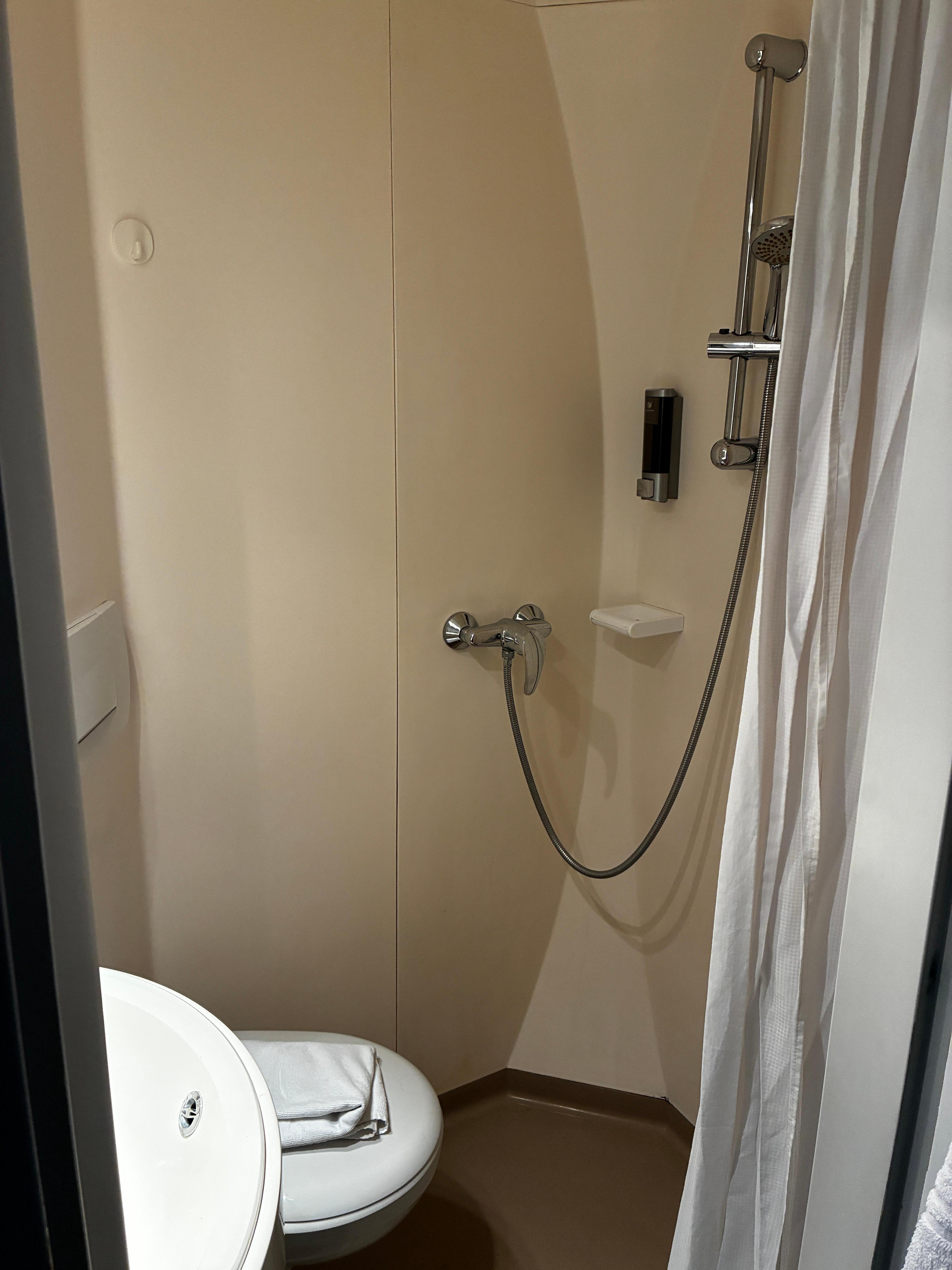 Salle de bains très propre, douche séparée du bol de toilette par un rideau MAIS très fonctionnelle 