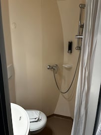Salle de bains très propre, douche séparée du bol de toilette par un rideau MAIS très fonctionnelle