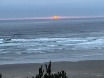 Sunset between bank of clouds and the ocean- from deck