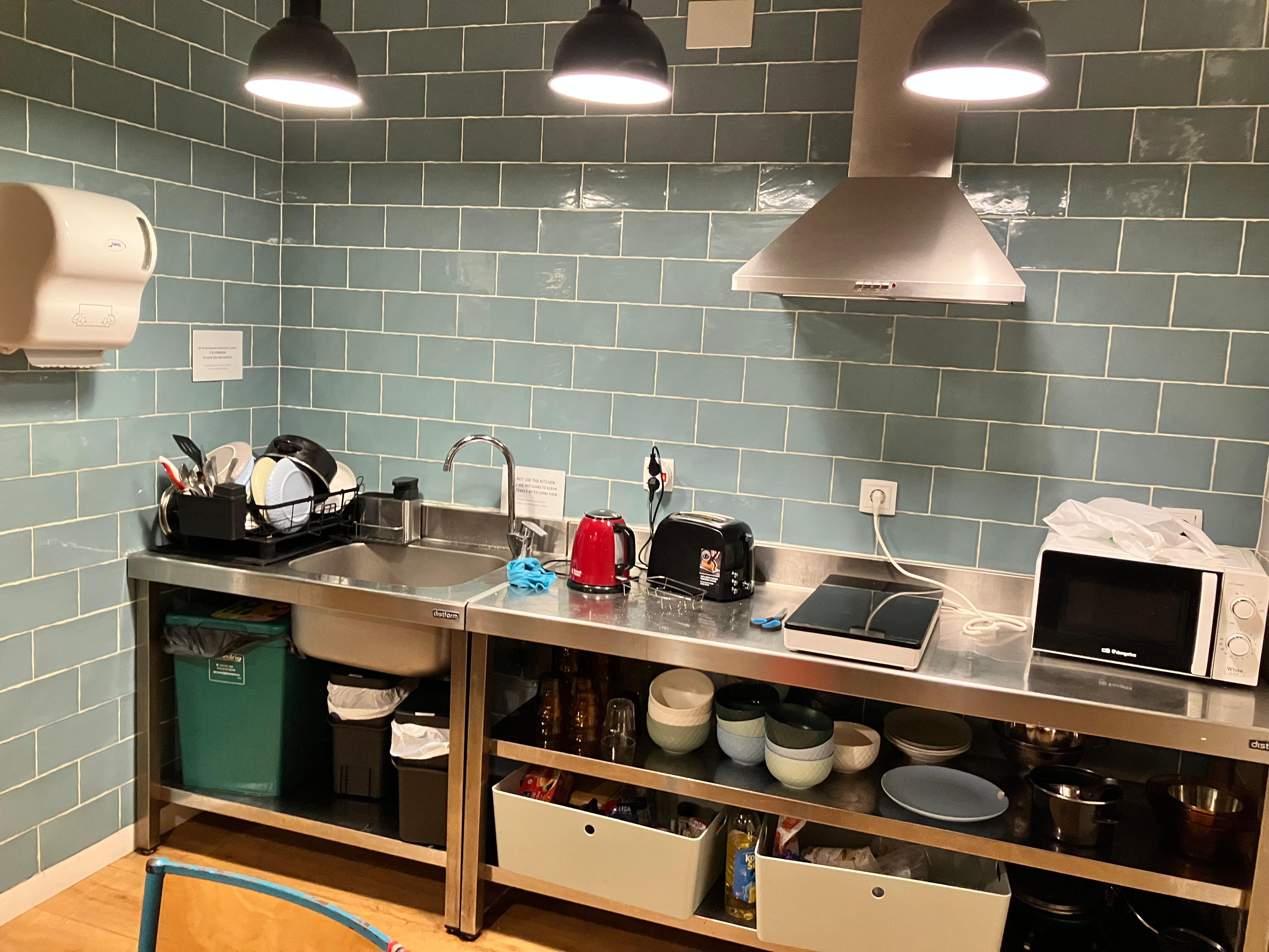 キッチンには写真の設備と反対側に冷蔵庫あり。テーブルと椅子が6脚。キッチンの奥にカウンターと椅子が4つ、さらに奥にソファとテーブルあり。