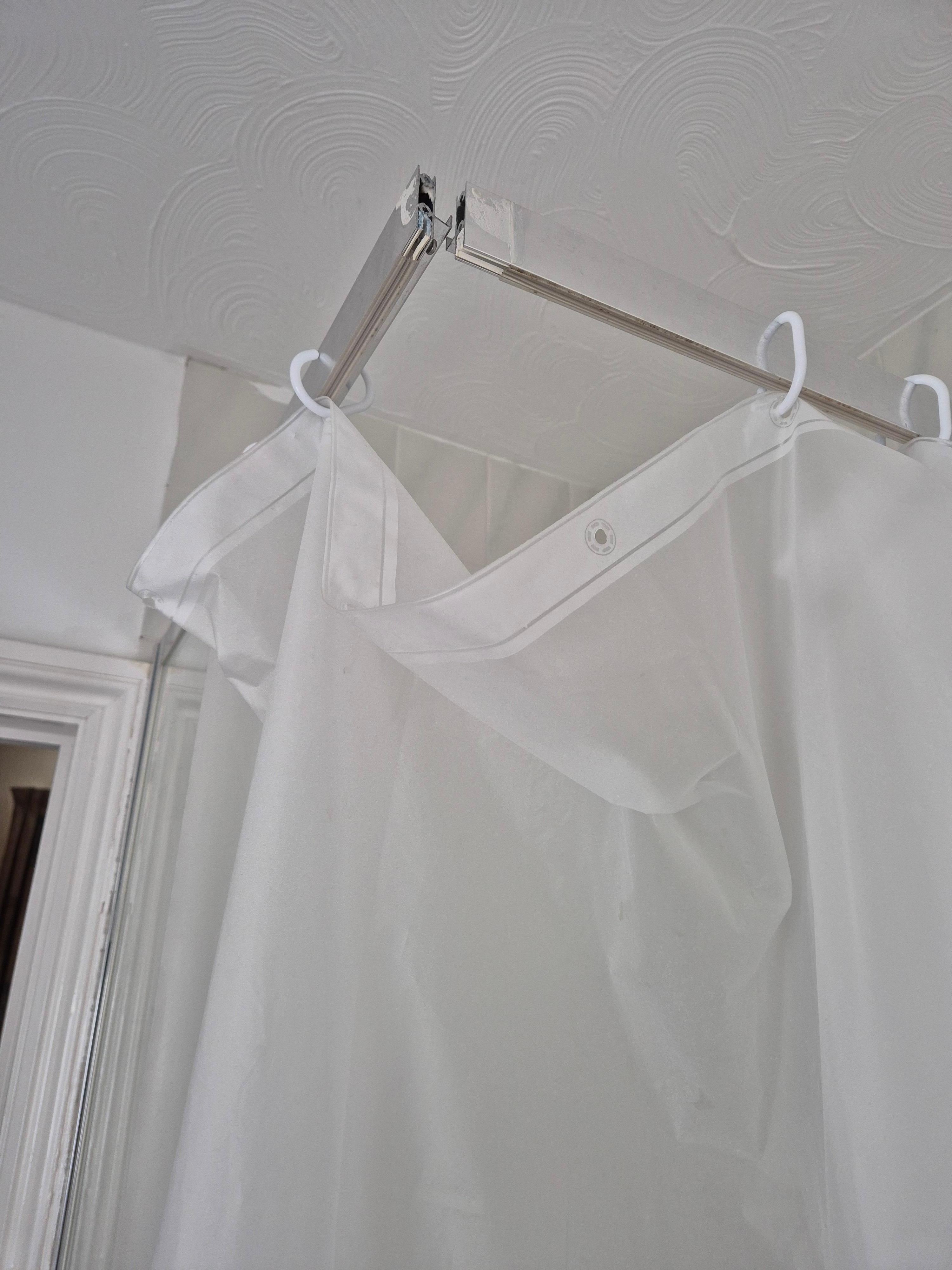 Shower cubicle with shower curtain and broken frame