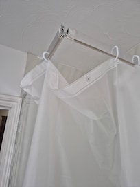 Shower cubicle with shower curtain and broken frame