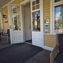 Trevlig entre, sittplatser med bord och stolar. Ger ett fräscht och välkomnande intryck.