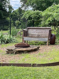 Fire pit and a vintage bench made from old car parts.