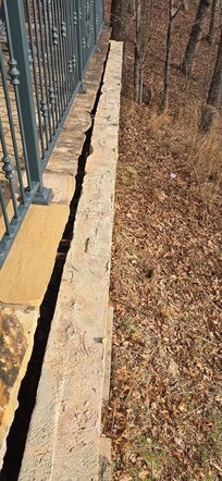 This is a pic showing the retaining wall sliding out and down the mountain. This is supposed to be under the stone patio. The patio is no longer supported and you can feel it flexing under your feet. I weight 210 pounds and it moves with just me.