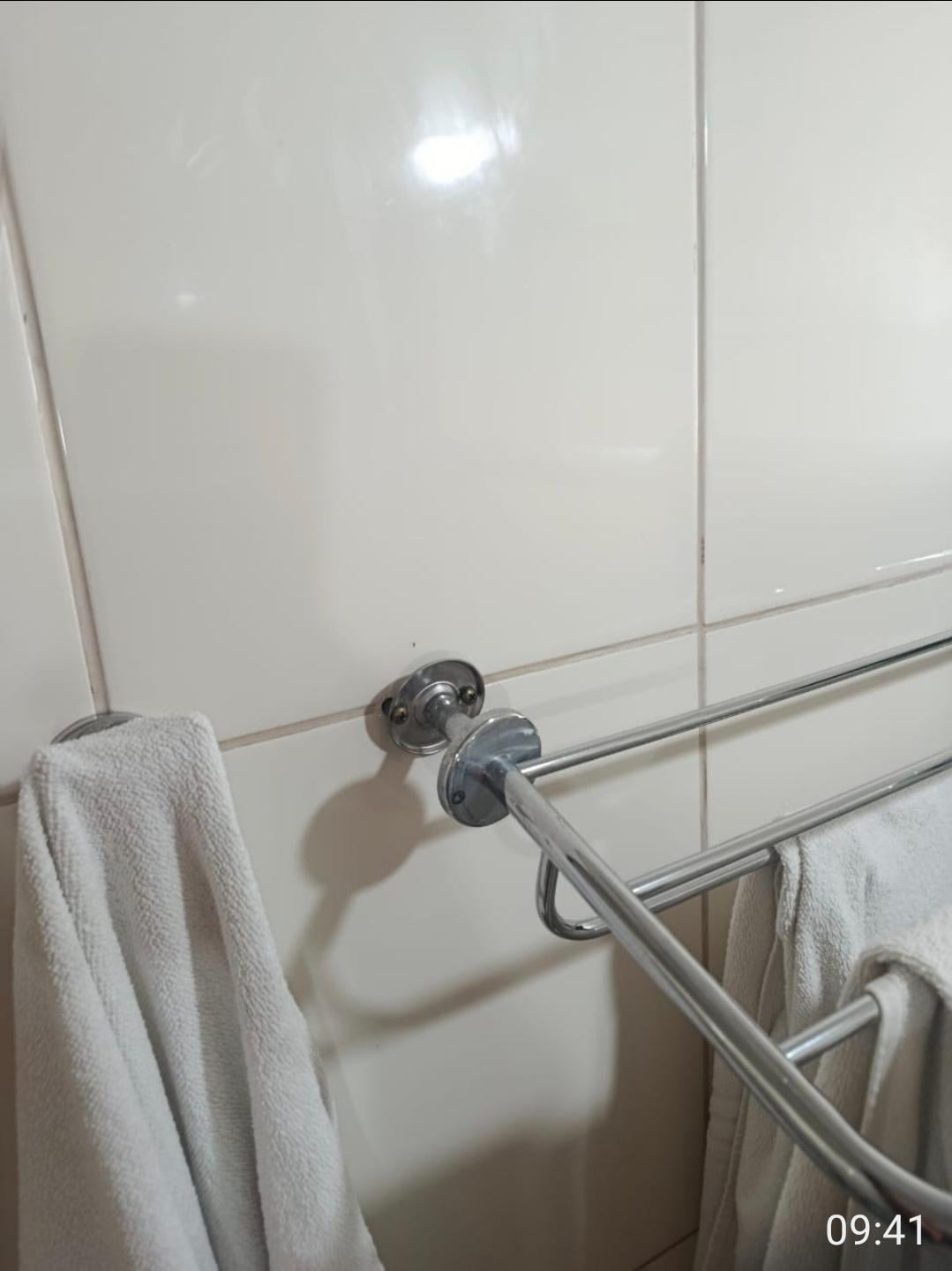 Toalheiro soltando da parede, acima do vaso. Podendo acontecer um acidente.