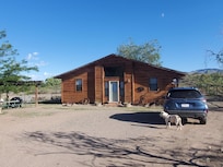 Gatehouse and parking area. Shaded sitting area and fire pit are off to the left.