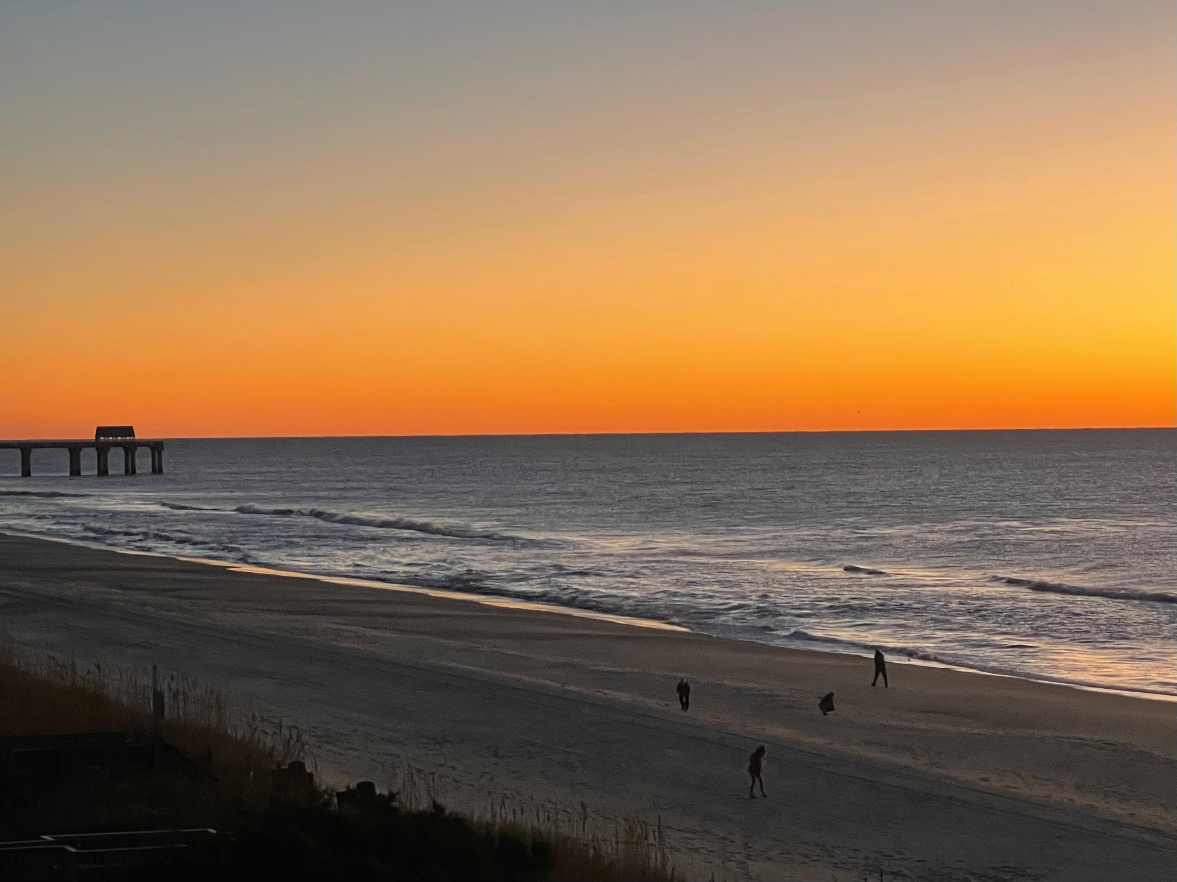 The Surfside Beach pier in the distance at sunrise.