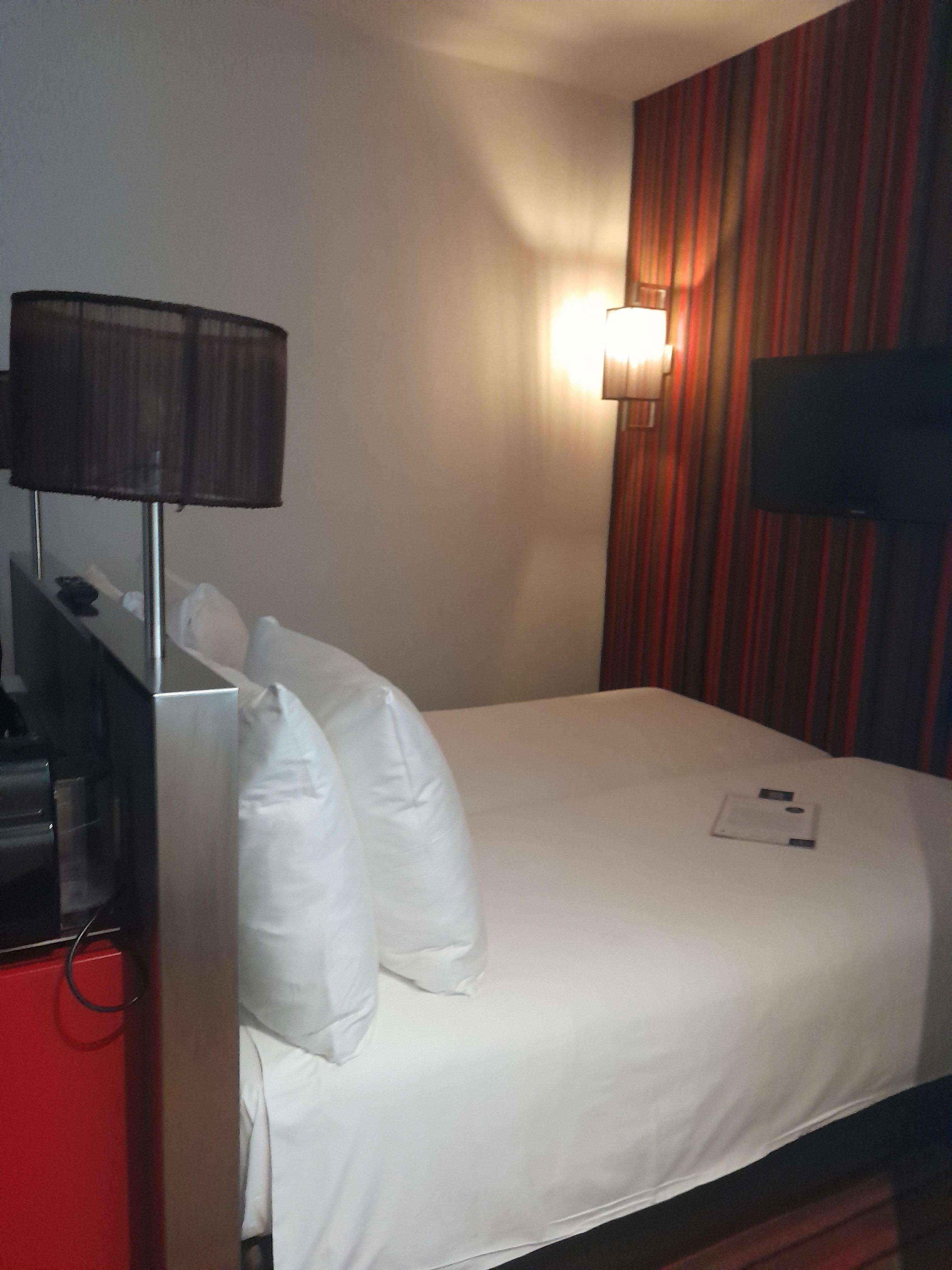 Head of bed buts up to desk with small 1 foot walk around. Foot of bed buts up to 70's style carpet wall. Beds were comfortable and bathrooms were nice