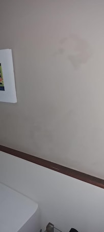 Infiltração e umidade nas paredes perto da cabeceira da cama.