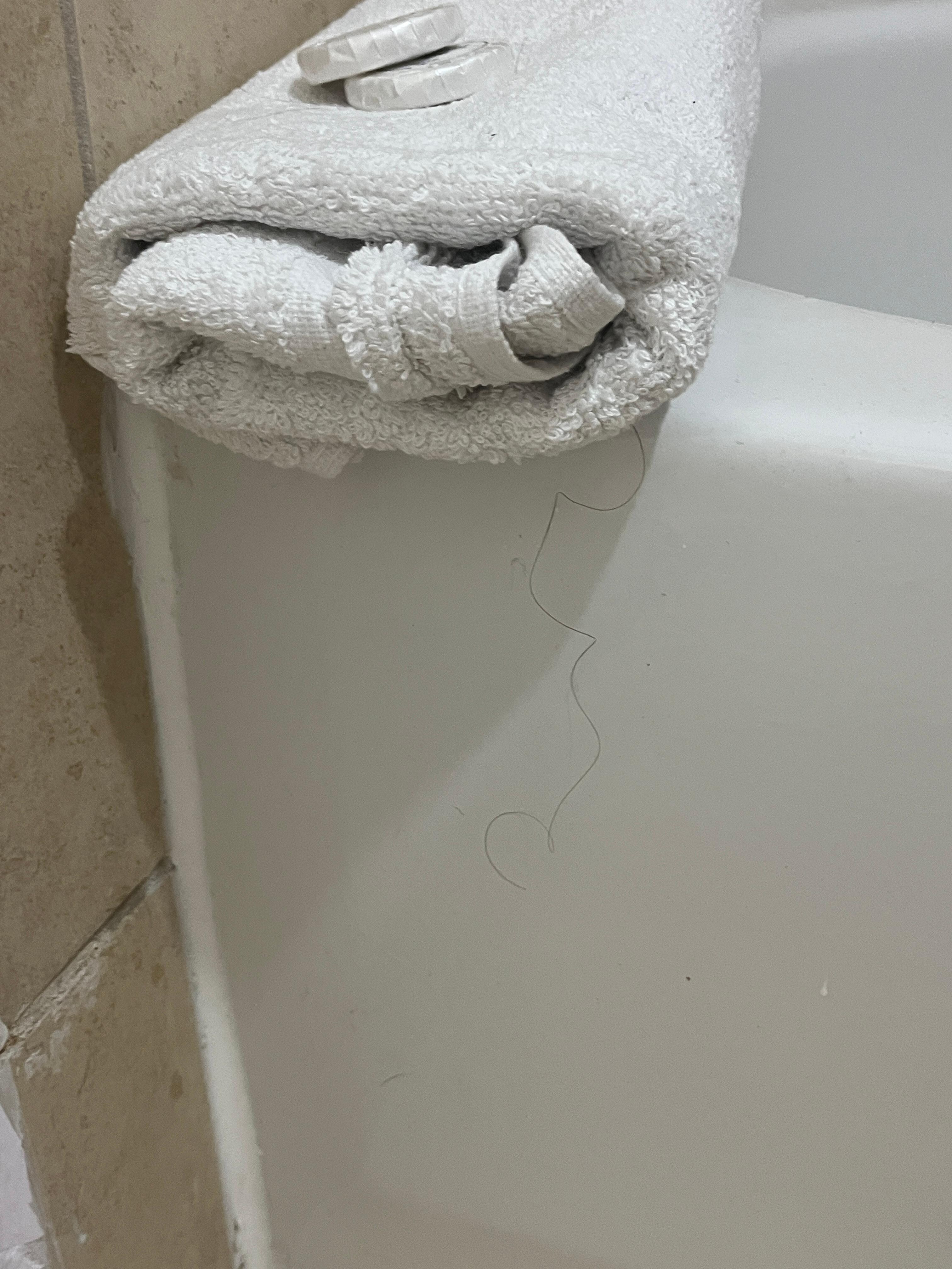 Long black hair hanging from the folded towel