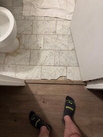 Cracked floor tile and loose transition strip