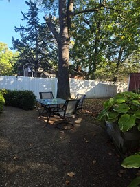 Private backyard with corn hole game and bikes extra chairs