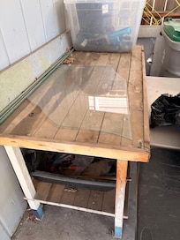 Carport area after we cleaned up. Piece of broken glass laying on bench.