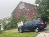 My ride with a barn in the background standing on the side porch.