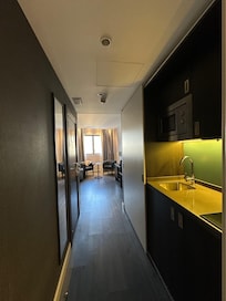 Fogão elétrico de duas bocas, pia com água quente, armário com utensílios domésticos, microondas, frigobar