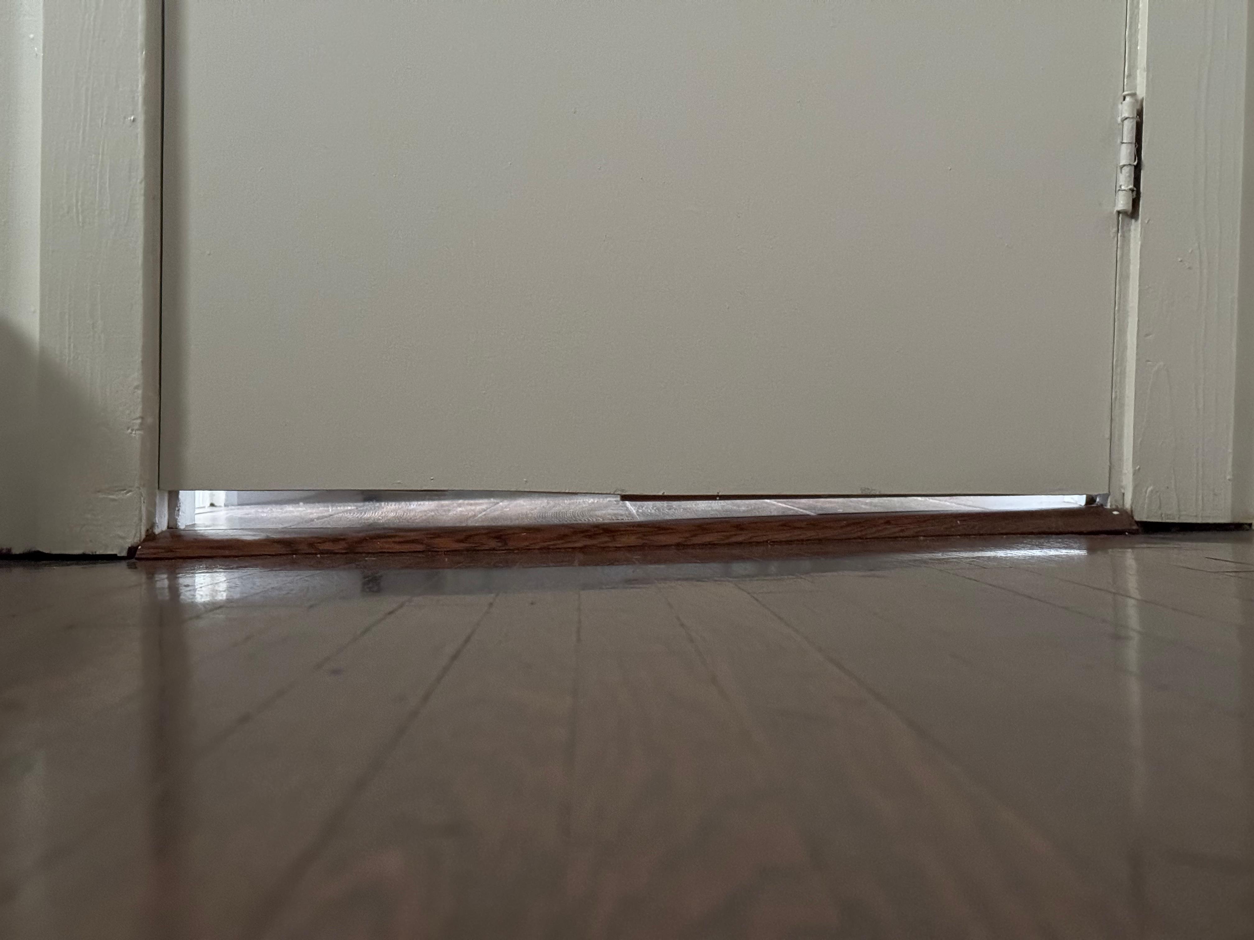 The door shows the gap on one side is more than the other due to the slant in the floor.