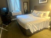 Spacious bedroom, but old furniture and dingy carpet.