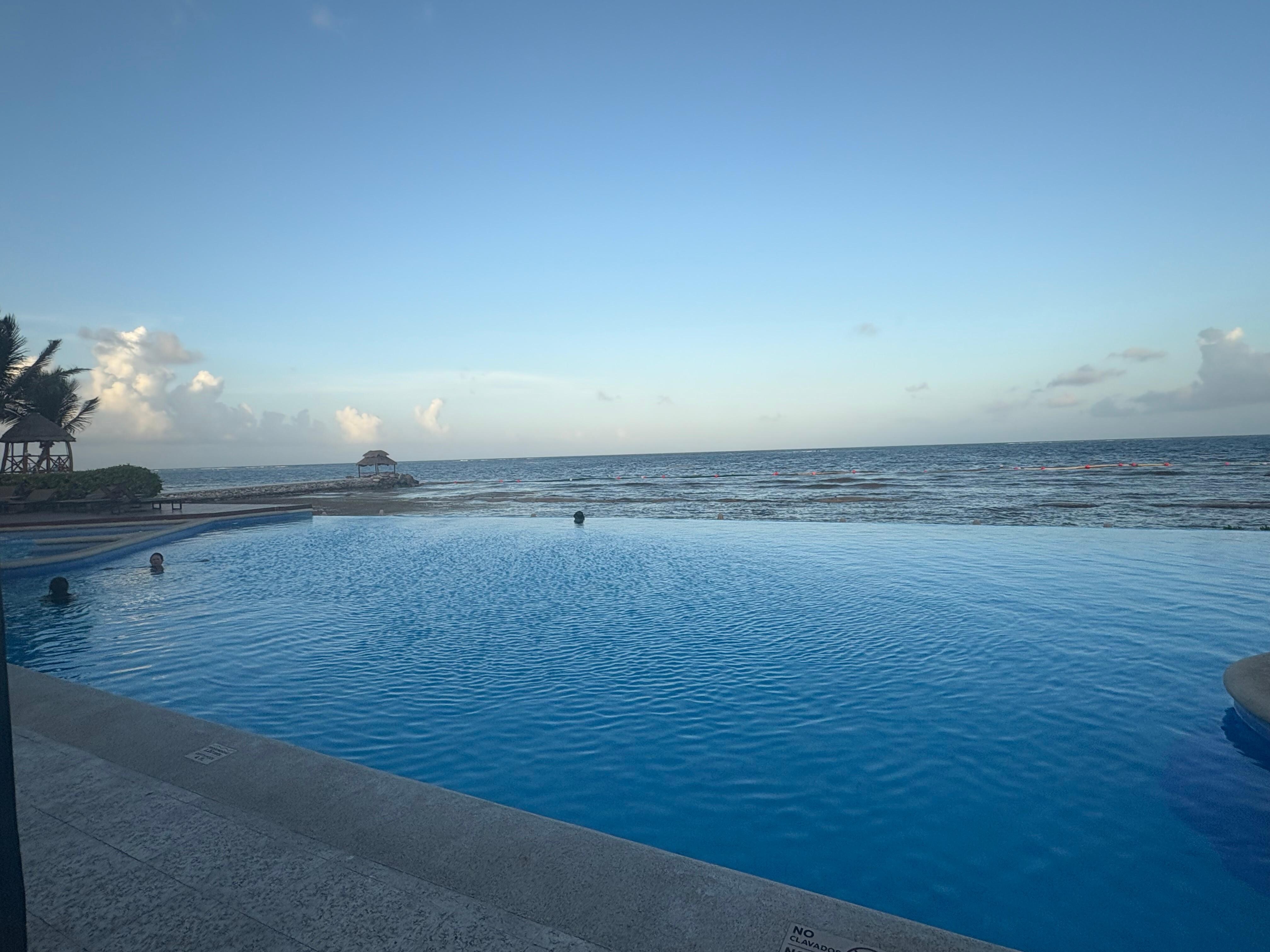 Adult infinity pool view with beach in front. 