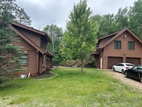 Main lodge on left, guest house on upper floor above garage