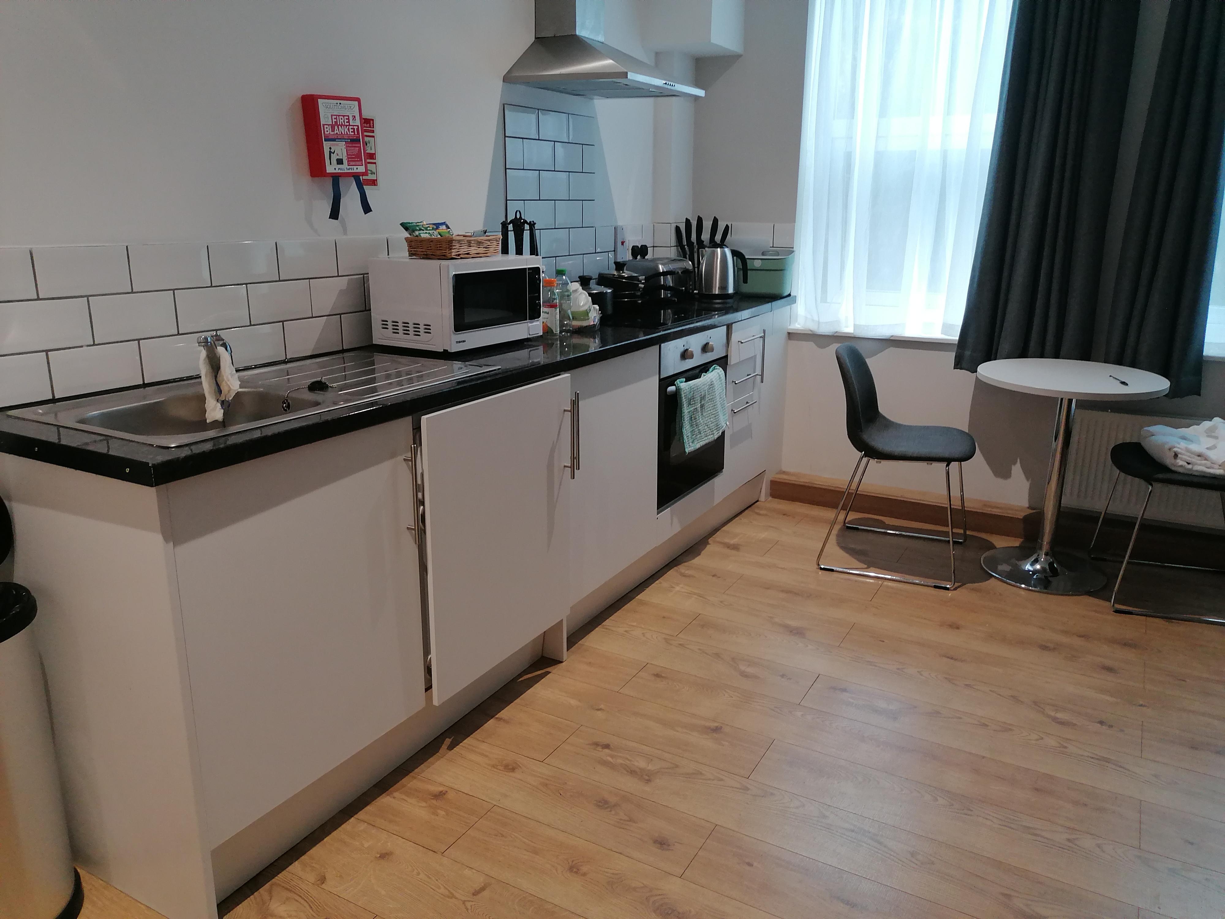 Kitchen area, washing machine in a cupboard. 