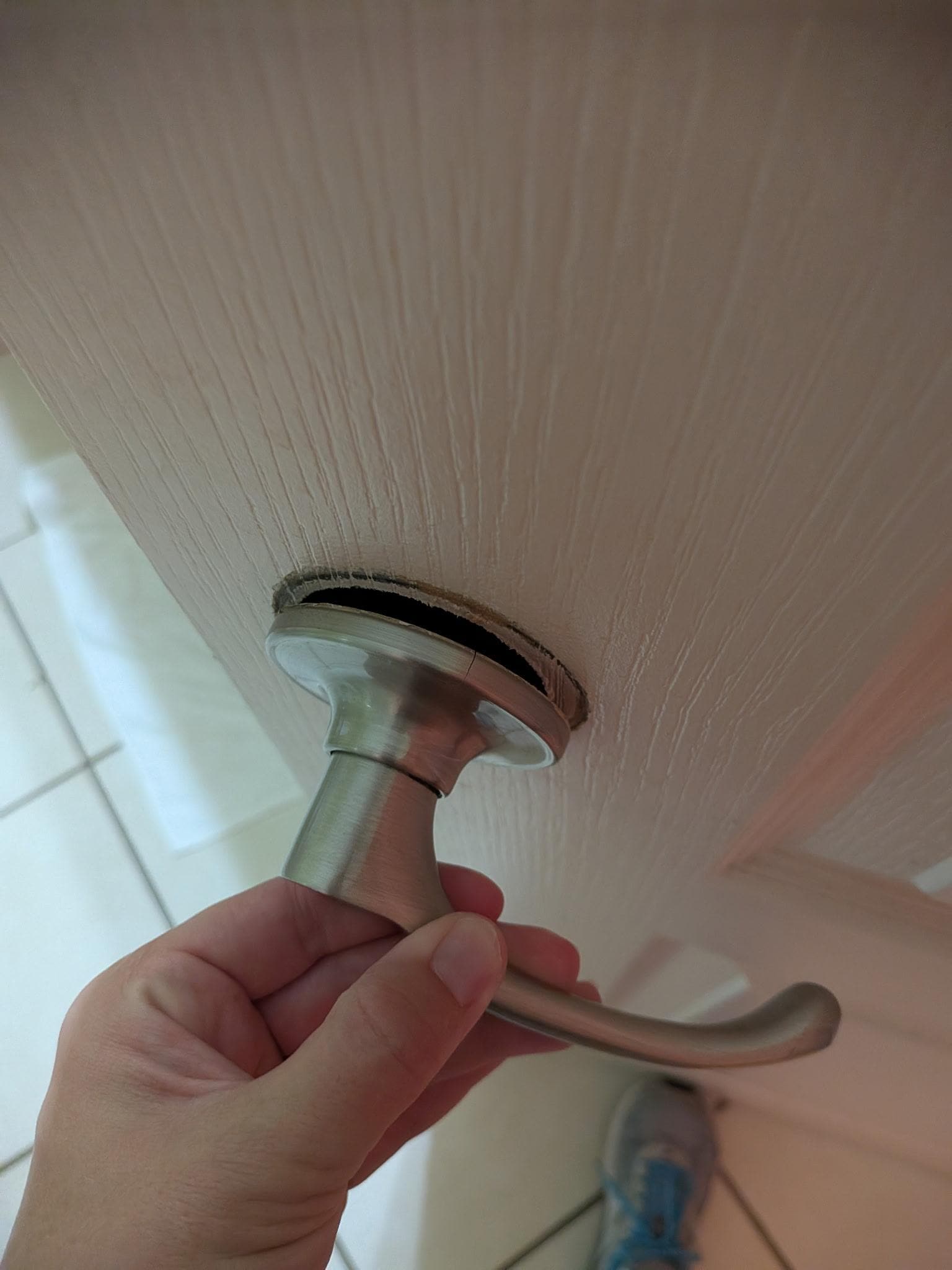 Door handle to bathroom barely hanging on