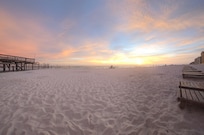 Sunset from beach beside pier just in front of condos
