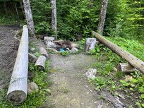 Campfire area with seating and view of pond.