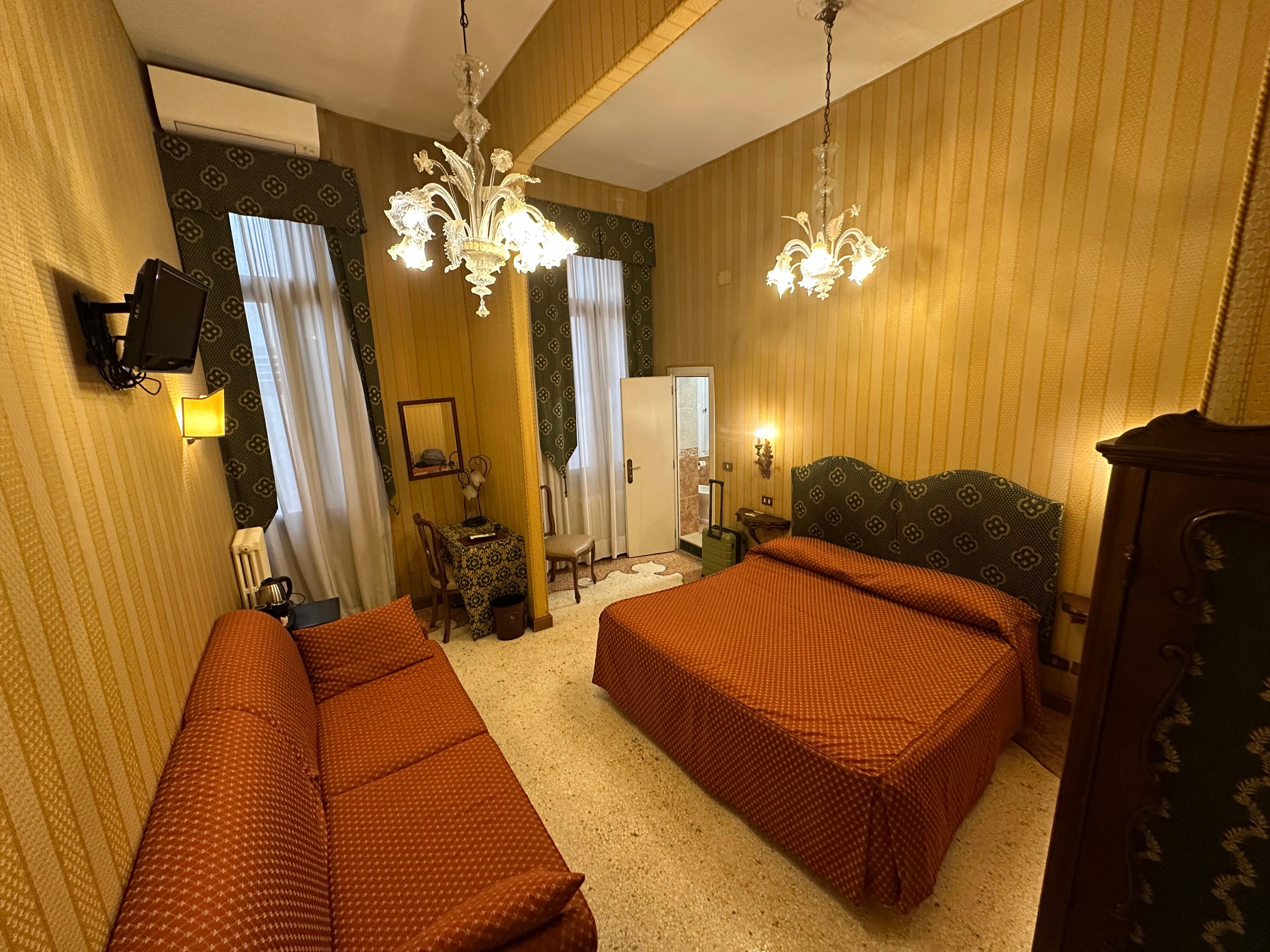 A double room. There’s a double bed and a single bed you can’t see here. A big sofa, private bathroom, and a small television.