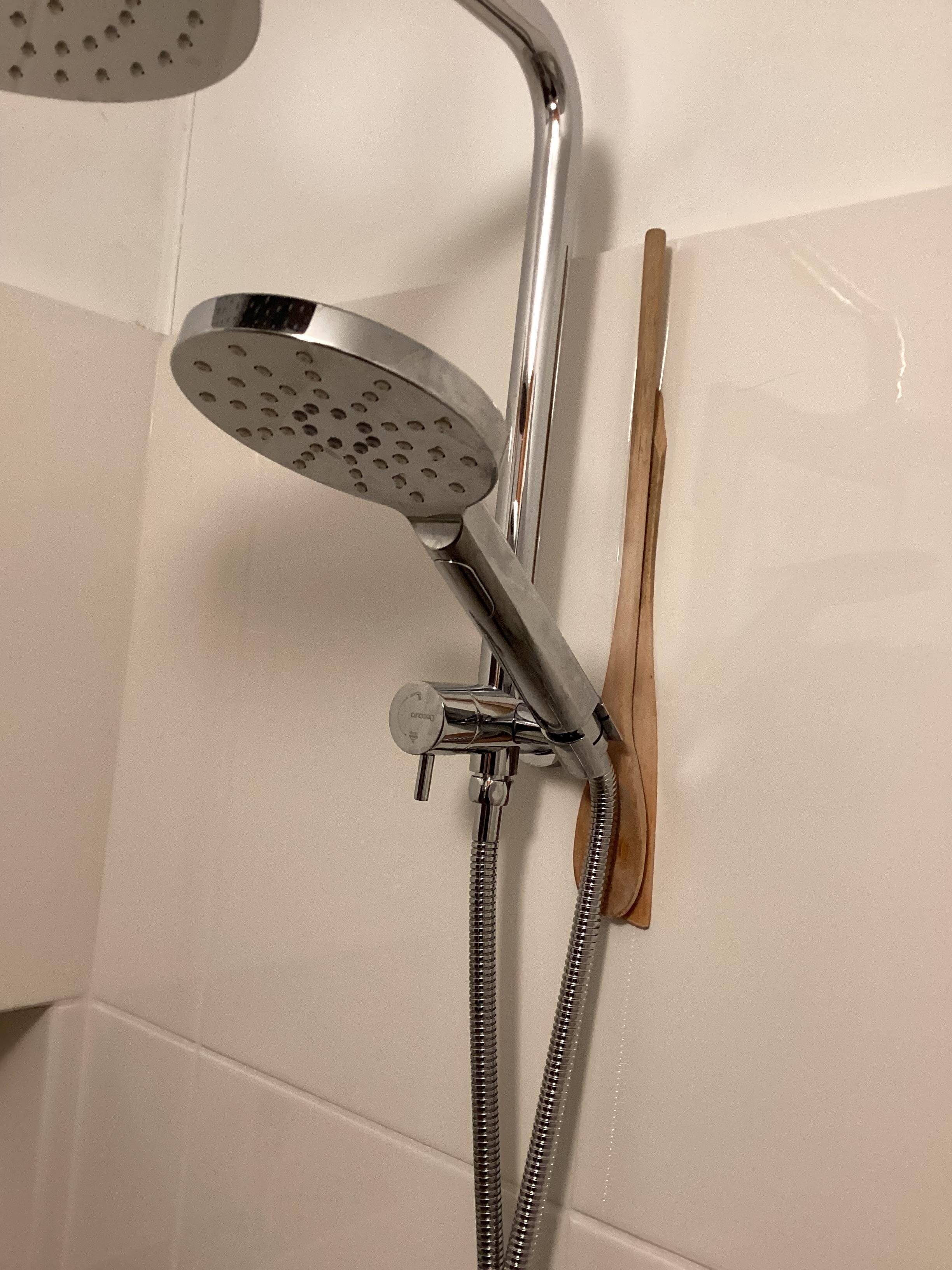 I used a couple of kitchen utensils to prop up the shower rose to prevent it from falling to the floor.