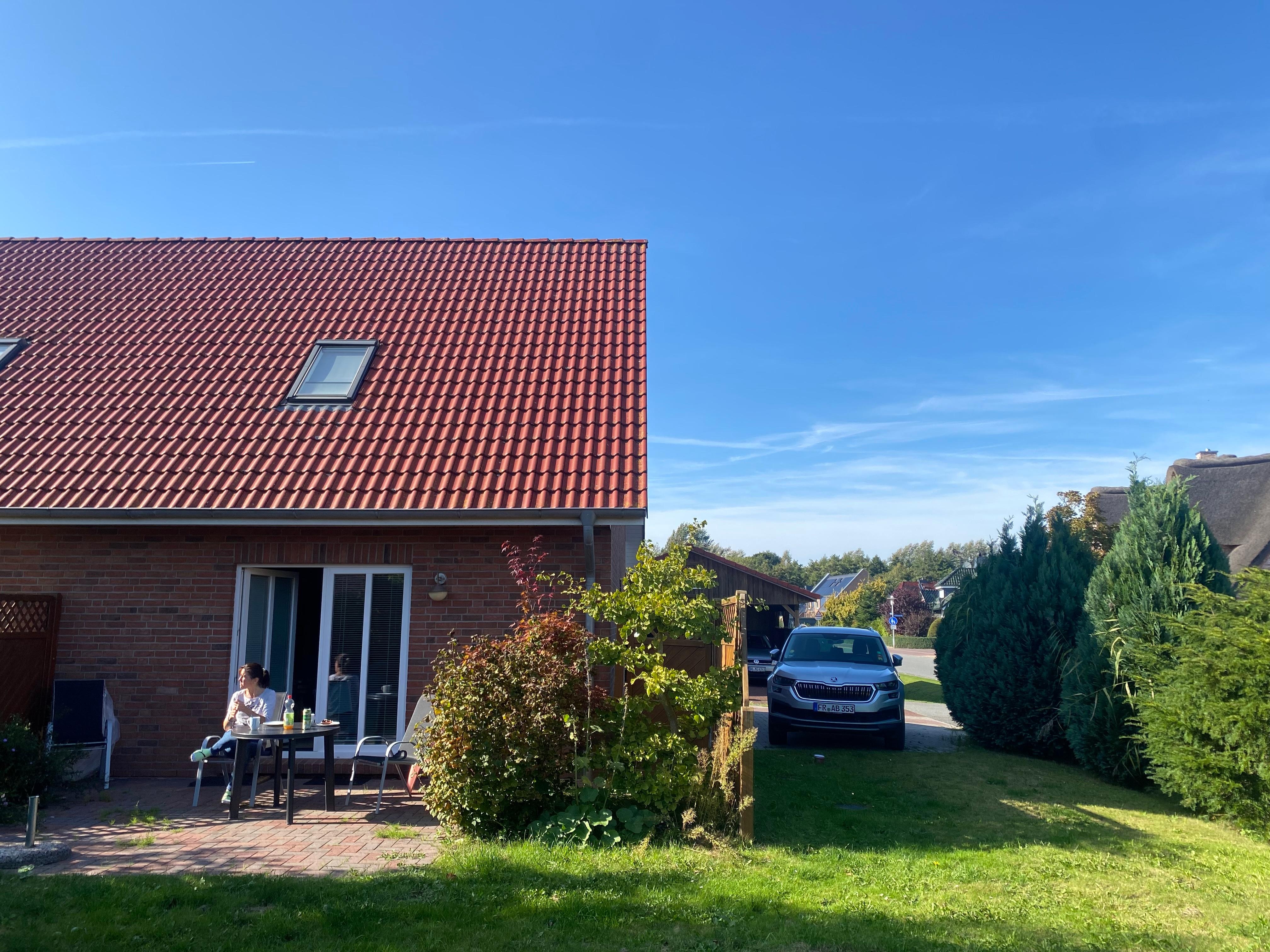 Das Ferienhaus mit Terrasse und Morgensonne, Stühle und Tisch sind da. 