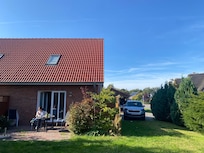 Das Ferienhaus mit Terrasse und Morgensonne, Stühle und Tisch sind da.