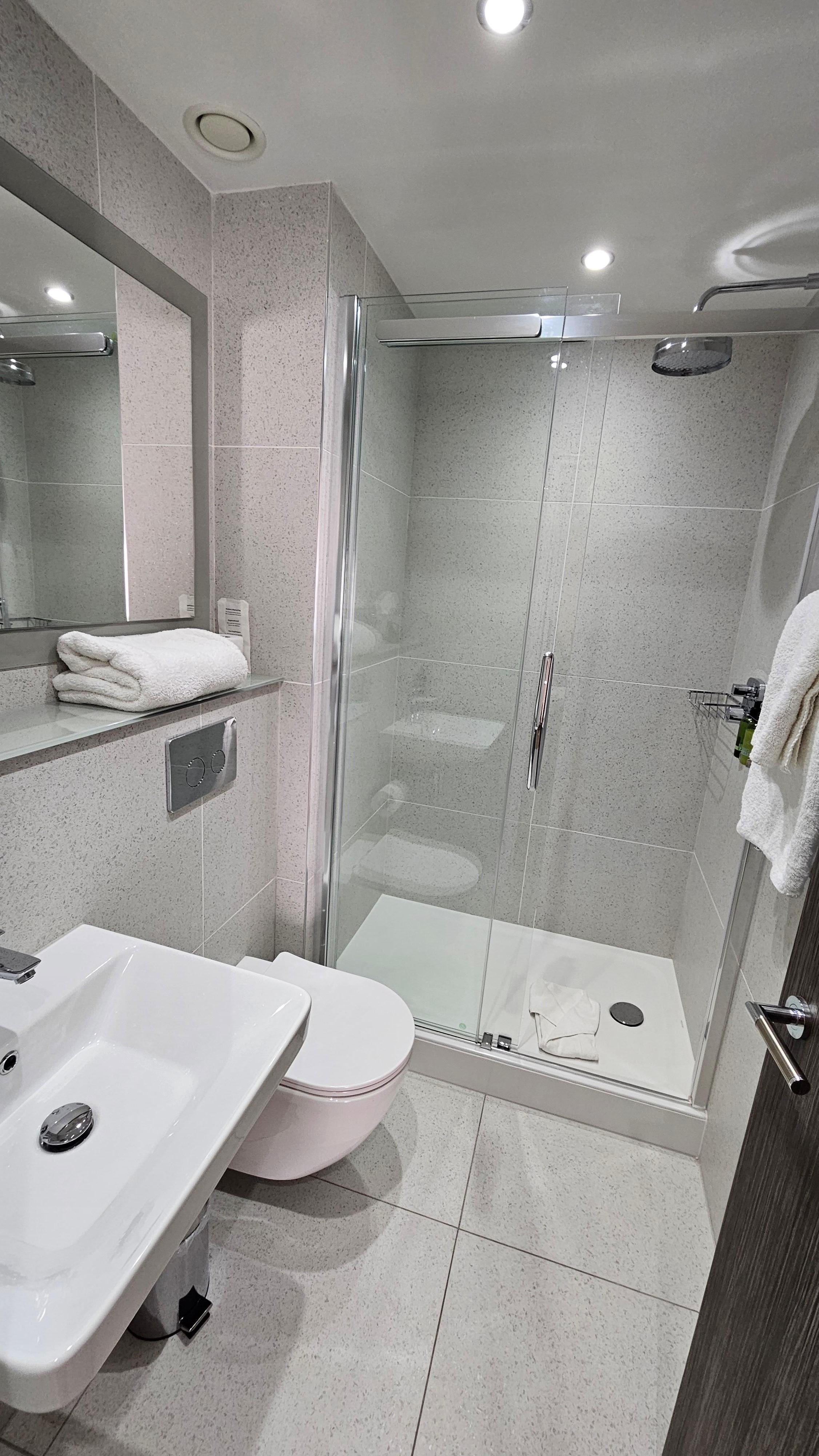 Beautiful washroom with rainfall showerhead and heated towel bar