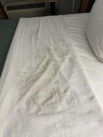 Stained sheet on made bed