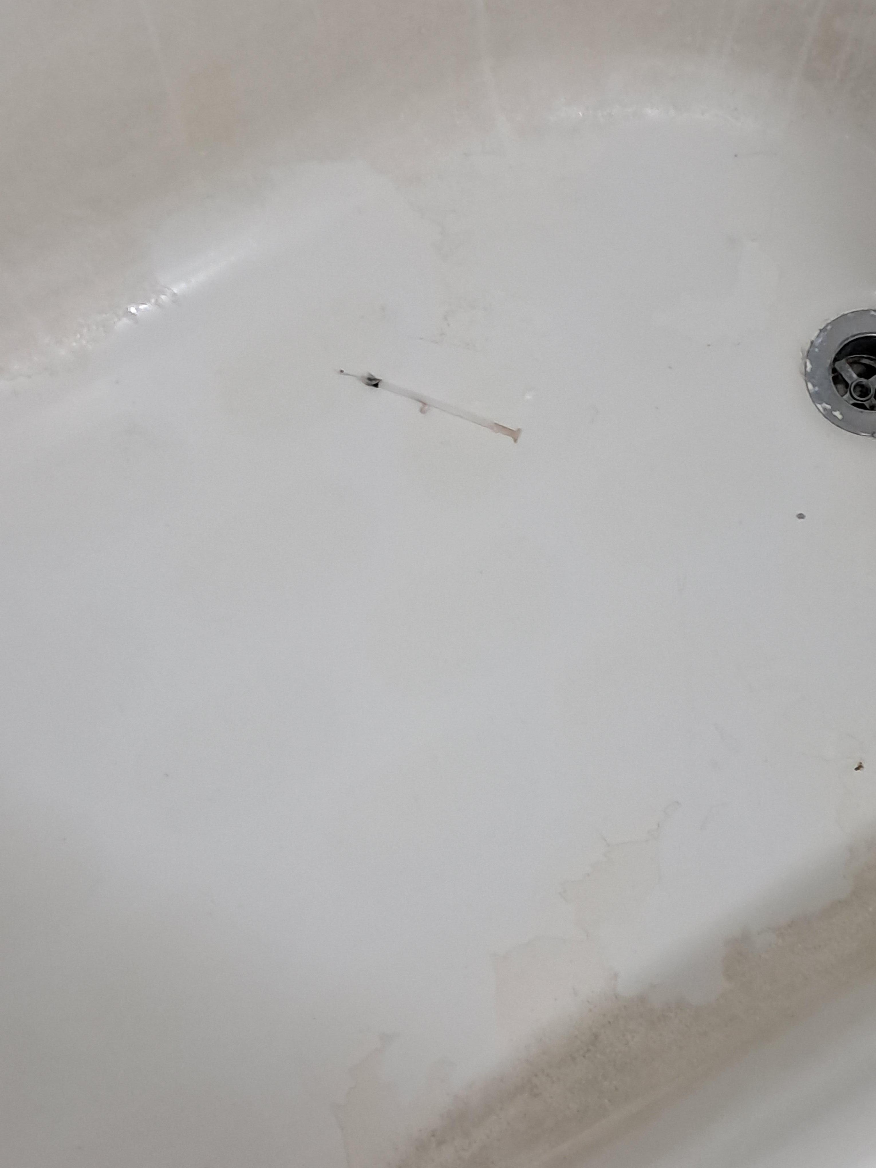 Dirty syringe in tub