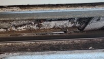 The window sill in the moldy bathroom filled with mold