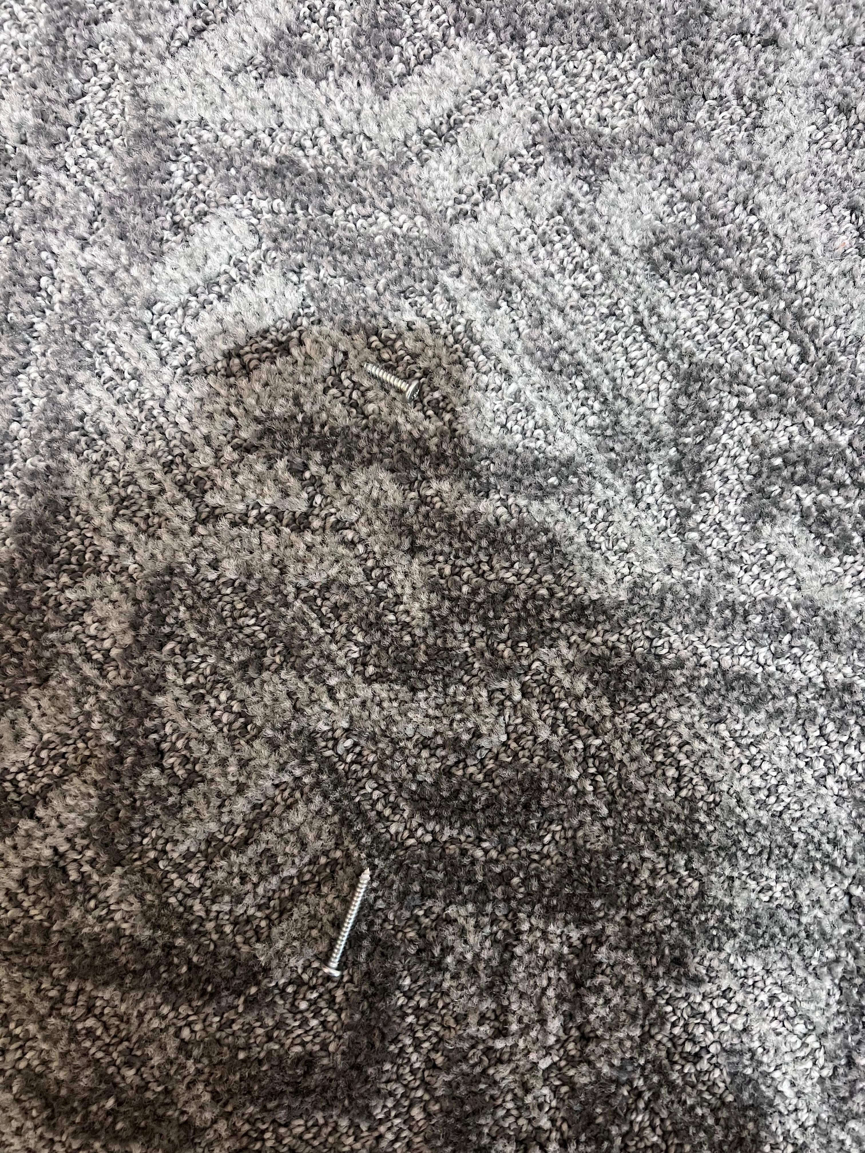 Screws on the floor outside the bathroom door.