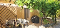 Terrasse principale pour les repas, abritée du soleil, avec barbecue