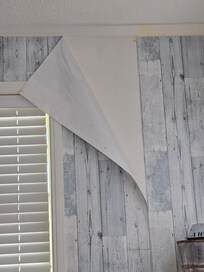Wall paper falling off the wall.