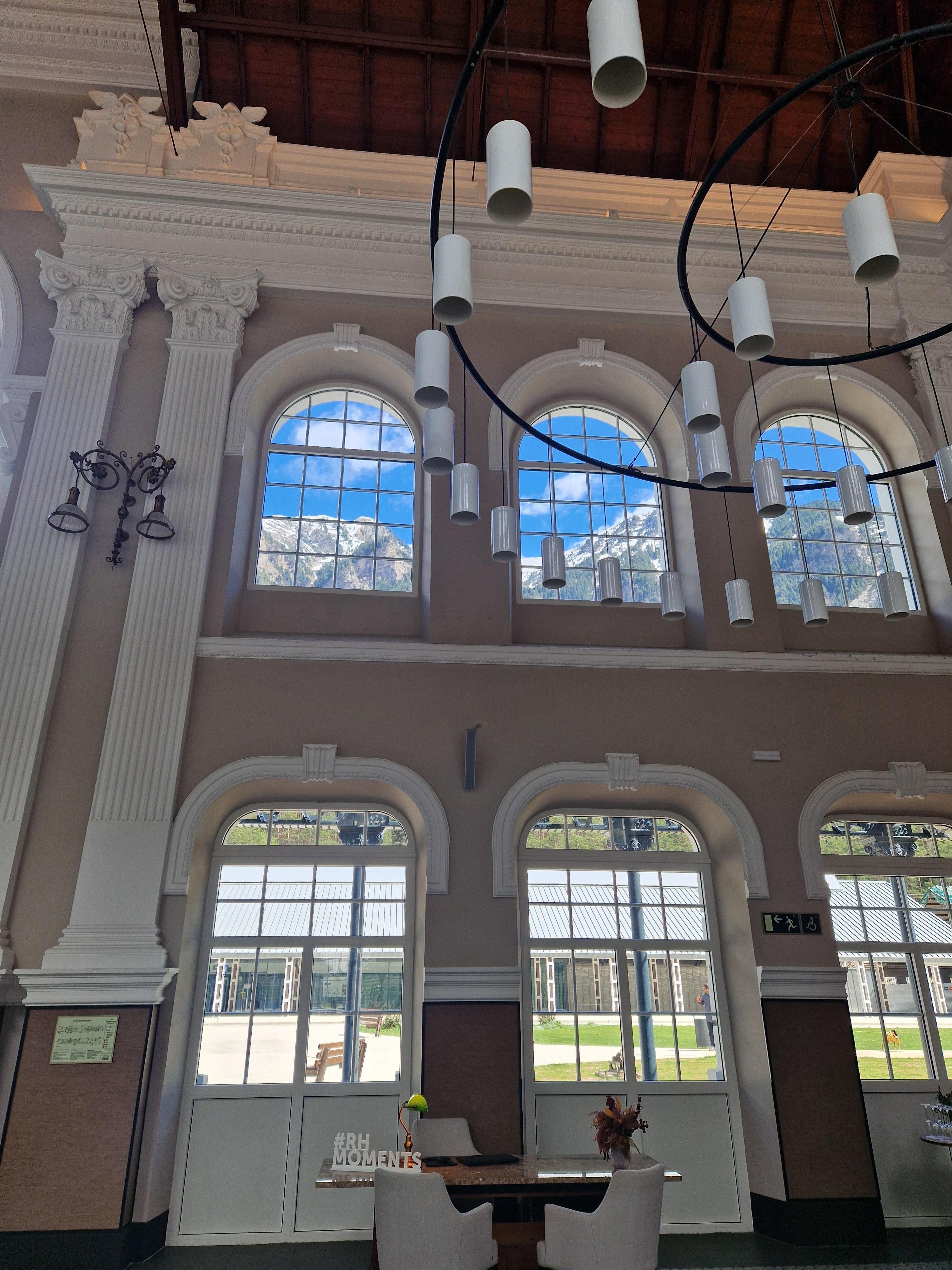 Looking through the arched windows from the foyer to the snow on mountains
