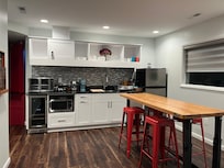 Kitchen with wine fridge, counter oven, microwave, and portable induction cooktop for stovetop option.